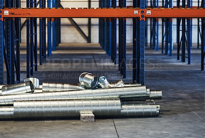 Buy stock photo Shot of metal sheets and pipes in an empty warehouse during the day