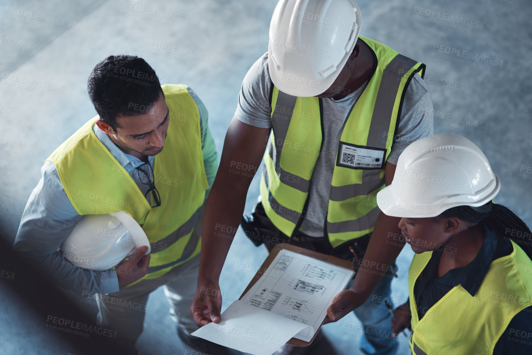 Buy stock photo High angle shot of a group of contractors standing in the warehouse together and having a discussion