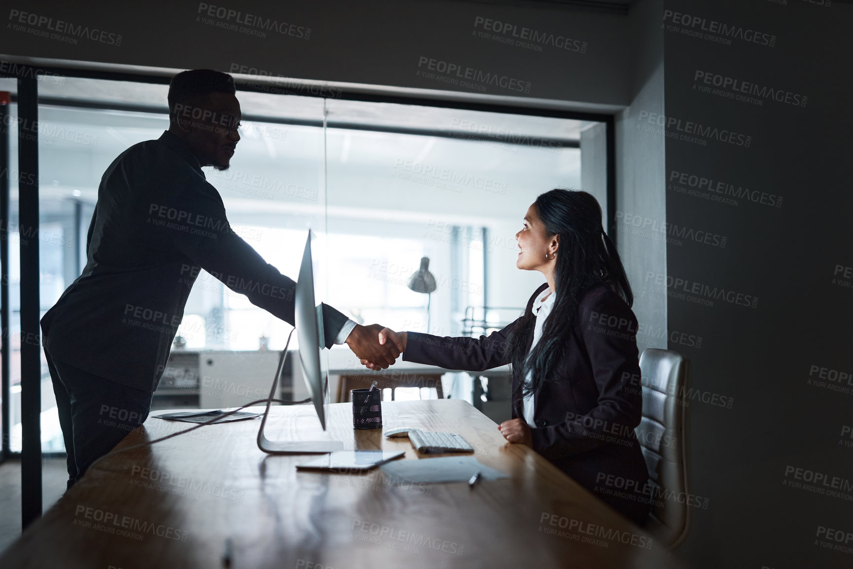 Buy stock photo Shot of Two businesspeople shaking hands in a modern office