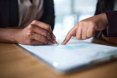 Buy stock photo Cropped shot of two businesspeople filling in paperwork in an office