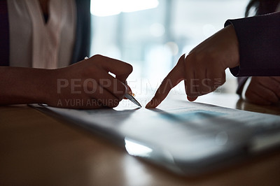 Buy stock photo Cropped shot of two businesspeople filling in paperwork in an office