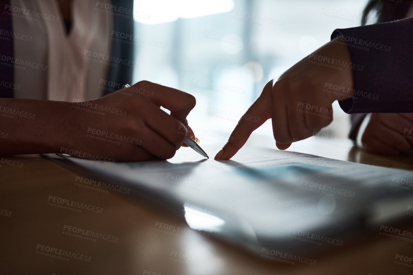 Buy stock photo Cropped shot of two businesspeople filling in paperwork in an office