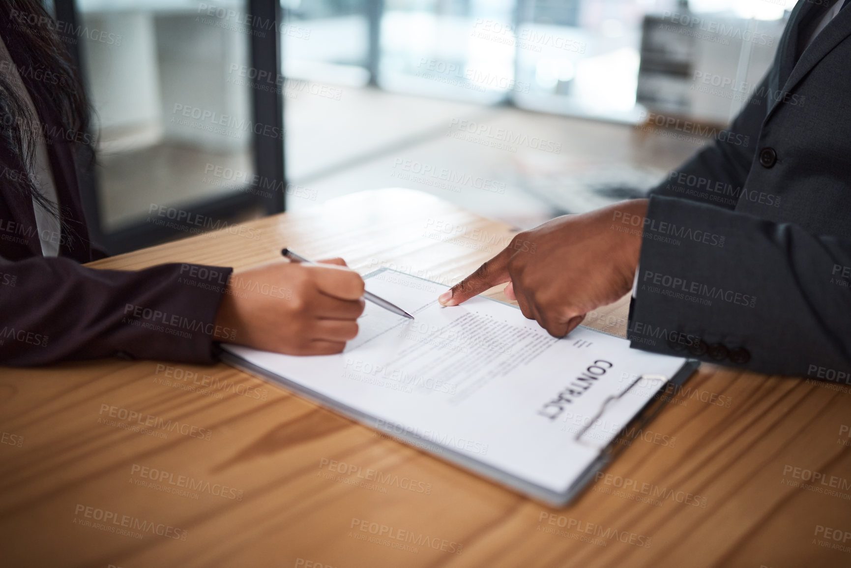 Buy stock photo Cropped shot of two businesspeople filling in paperwork in an office