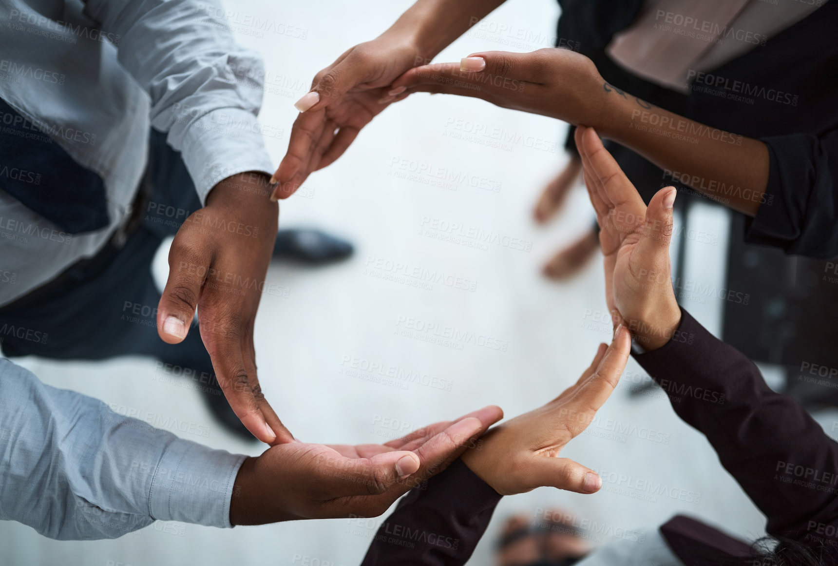 Buy stock photo High angle shot of a group of unidentifiable businesspeople forming a circle with their hands