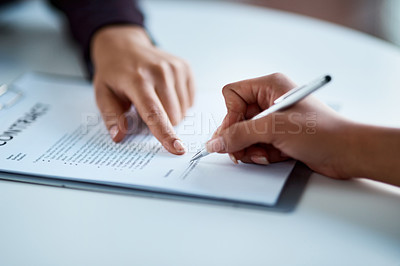 Buy stock photo Cropped shot of two businesspeople filling in paperwork in an office