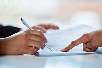 Buy stock photo Cropped shot of two businesspeople filling in paperwork in an office