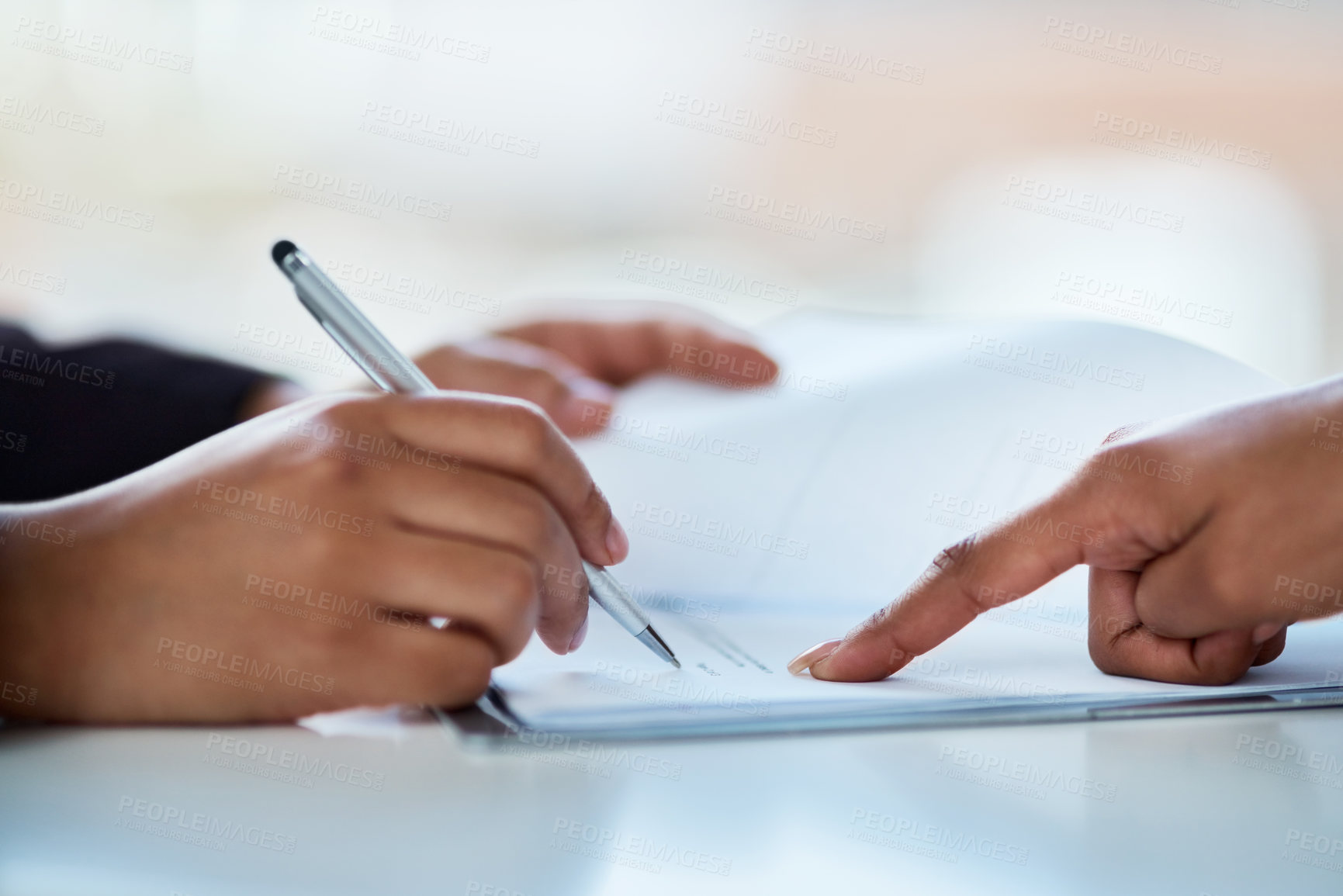 Buy stock photo Cropped shot of two businesspeople filling in paperwork in an office