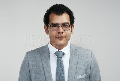 Buy stock photo Studio shot of a businessman wearing glasses while standing against a grey background