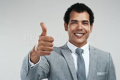 Buy stock photo Studio shot of a confident businessman showing thumbs up while standing against a grey background