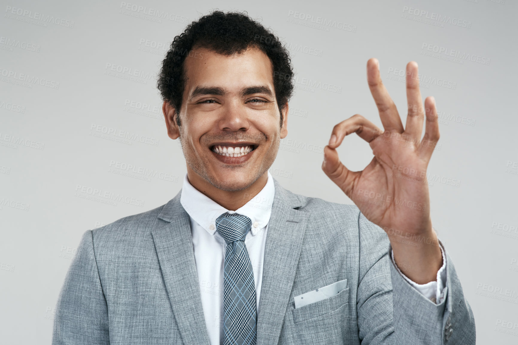 Buy stock photo Studio shot of a businessman showing the ok sign while standing against a grey background