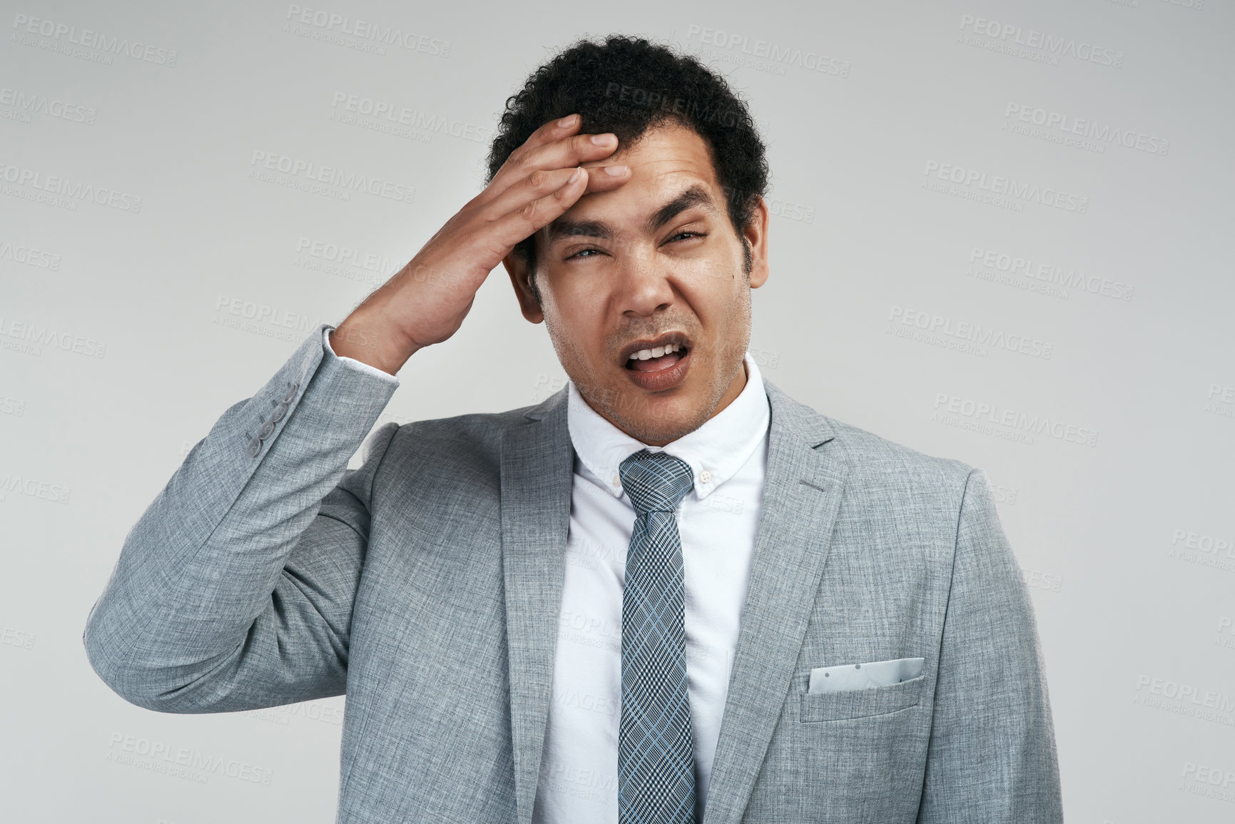 Buy stock photo Studio shot of a businessman looking stressed while standing against a grey background