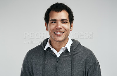 Buy stock photo Shot of a handsome young man standing against a grey background