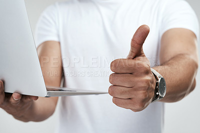 Buy stock photo Shot of an unrecognizable man showing thumbs up while holding his laptop