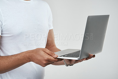 Buy stock photo Studio shot of an unrecognizable man holding a laptop