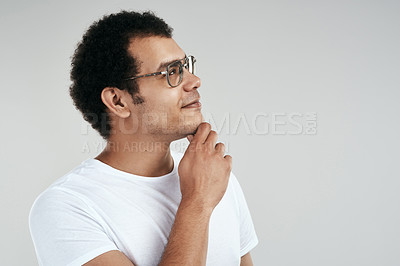 Buy stock photo Studio shot of a man looking thoughtful while standing against a grey background