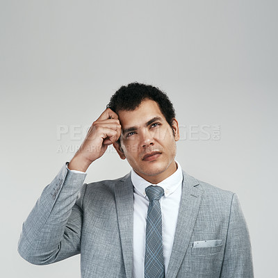 Buy stock photo Studio shot of a businessman looking confused while standing against a grey background