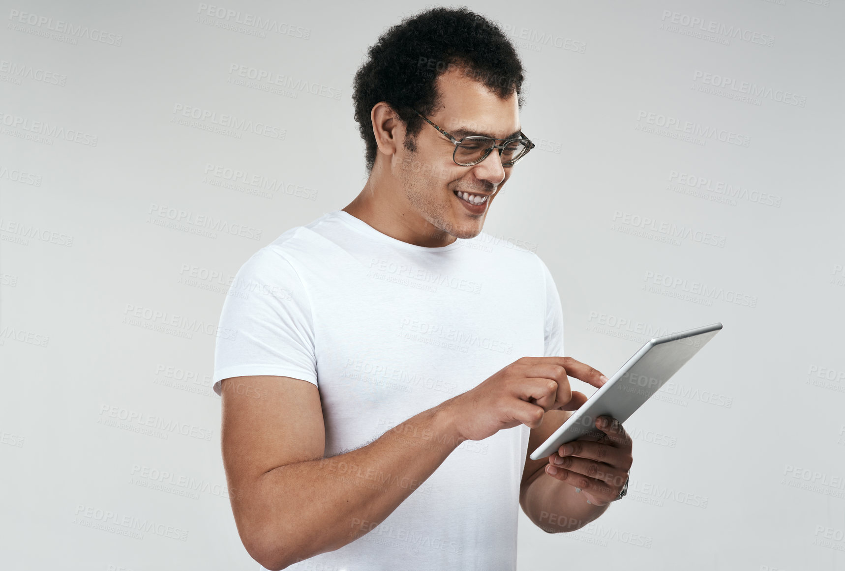 Buy stock photo Shot of a man using a digital tablet while standing against a grey background