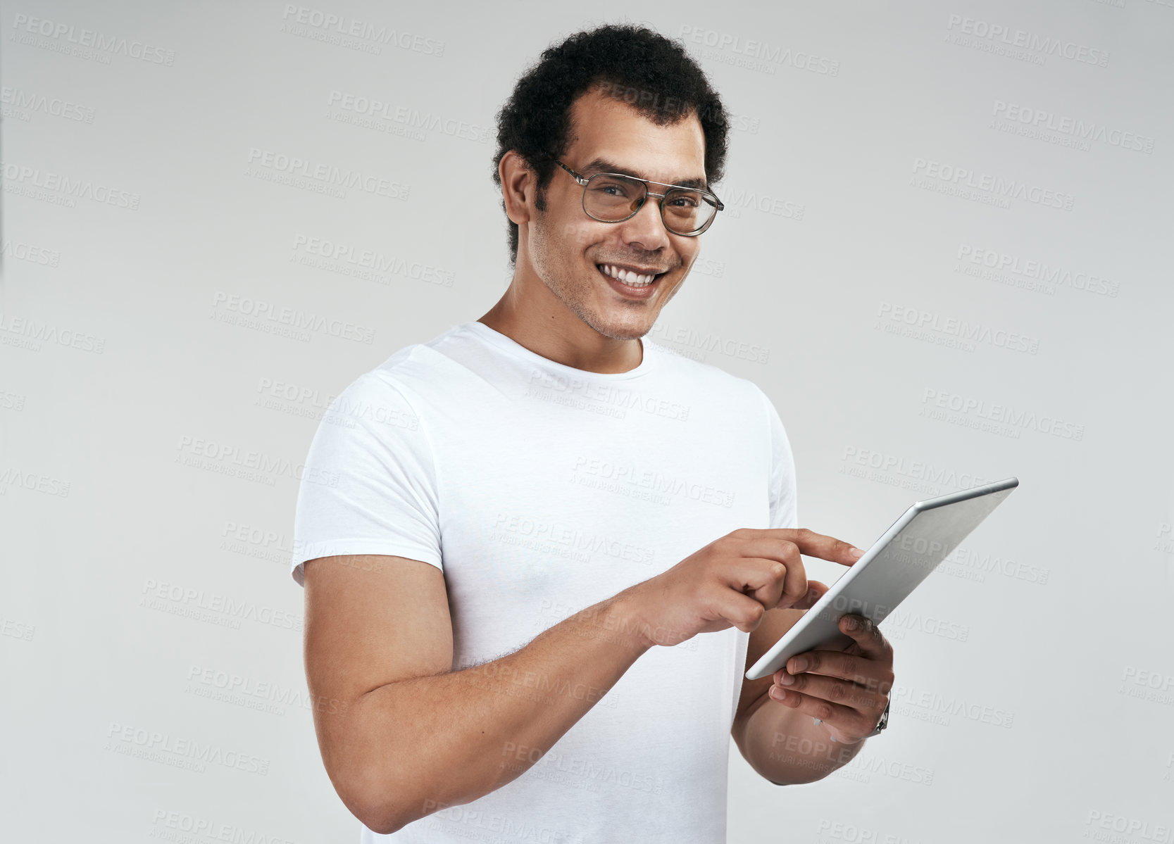 Buy stock photo Shot of a man using a digital tablet while standing against a grey background