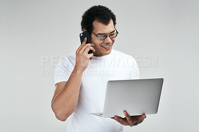 Buy stock photo Studio shot of a man talking on her cellphone while holding his laptop