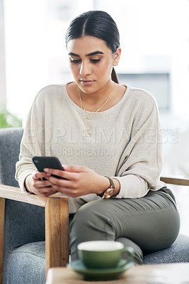 Buy stock photo Shot of a young businesswoman using a cellphone in an office