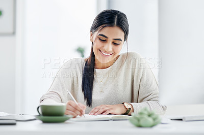Buy stock photo Shot of a young businesswoman writing notes in an an office