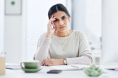 Buy stock photo Shot of a young businesswoman looking stressed out while working in an office