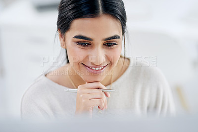 Buy stock photo High angle shot of a young businesswoman looking thoughtful while working on a computer in an office