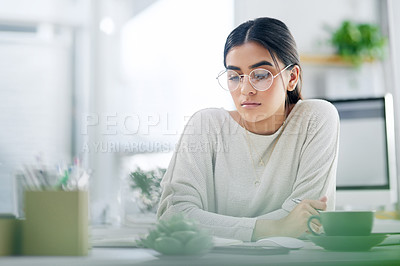 Buy stock photo Shot of a young businesswoman reading through a notebook in an office