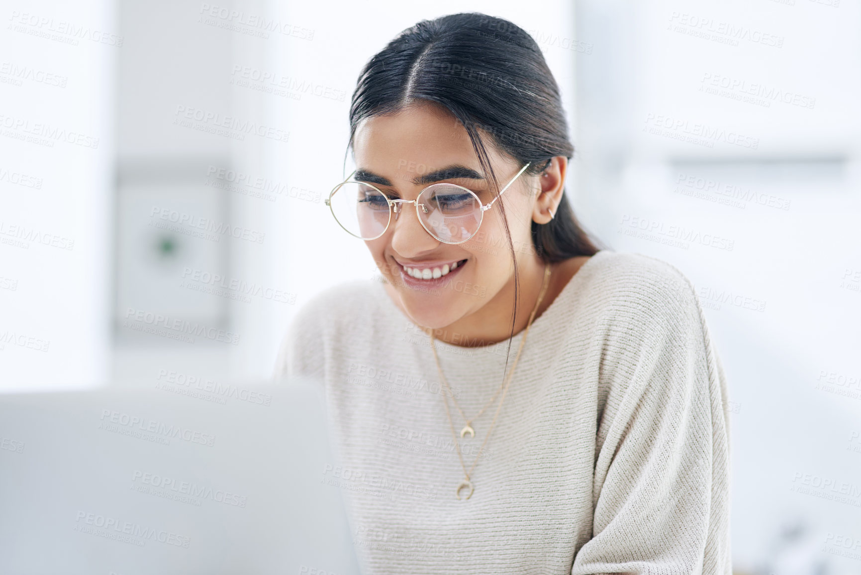 Buy stock photo Shot of a young businesswoman working on a laptop in an office