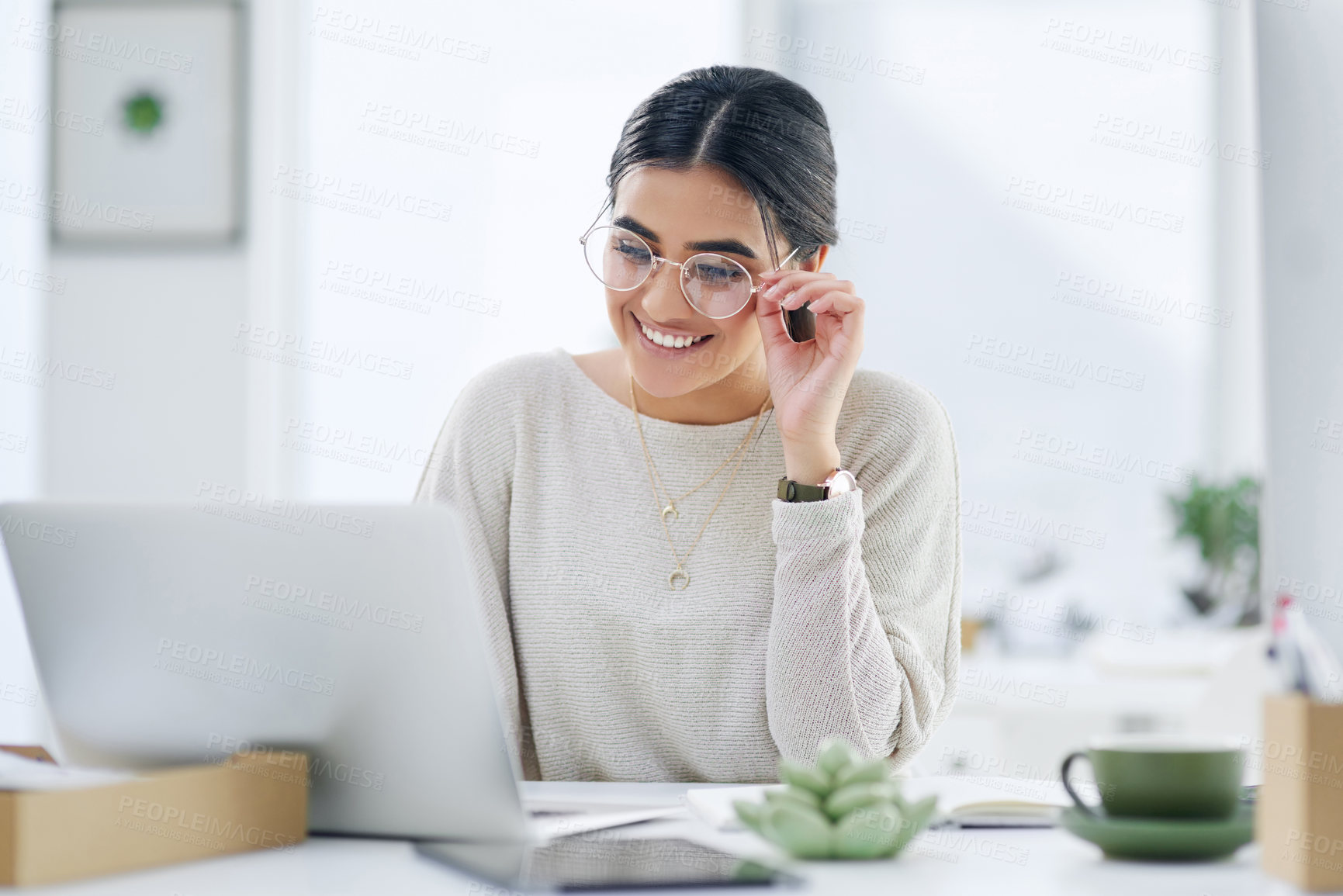 Buy stock photo Shot of a young businesswoman working on a laptop in an office