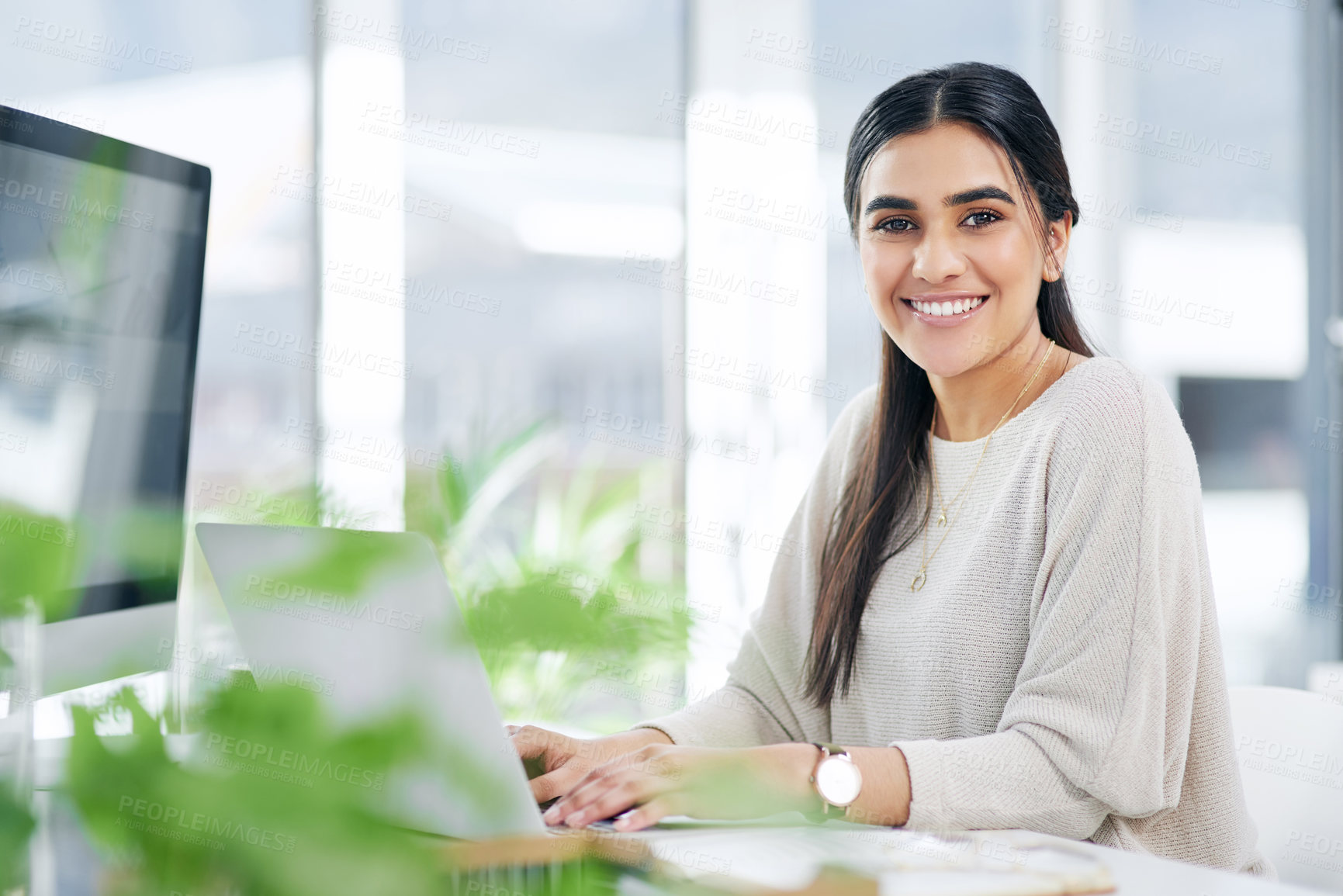 Buy stock photo Portrait of a young businesswoman working on a laptop in an office