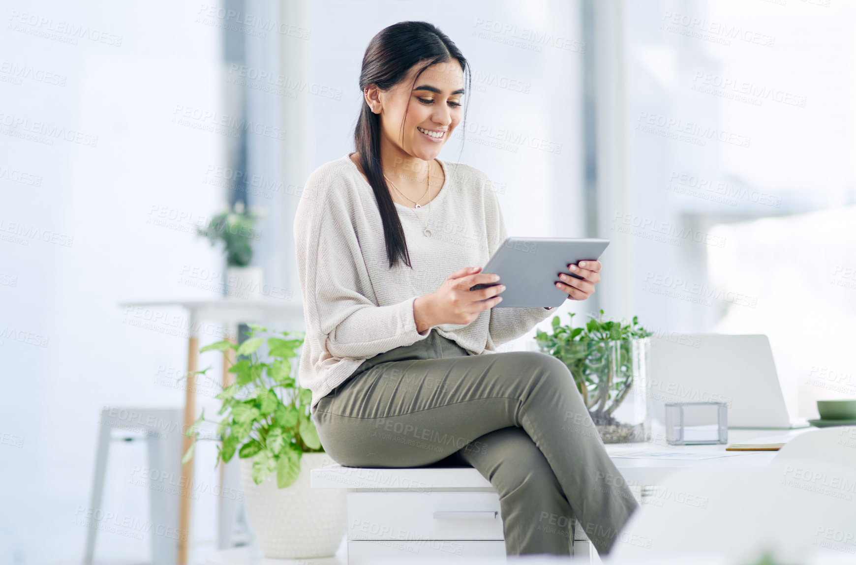 Buy stock photo Shot of a young businesswoman using a digital tablet in an office