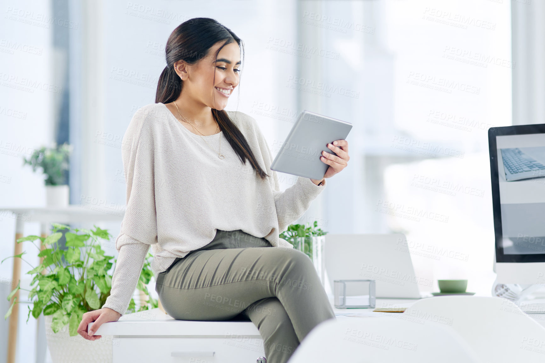 Buy stock photo Shot of a young businesswoman using a digital tablet in an office