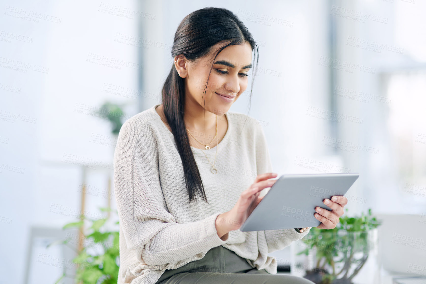 Buy stock photo Shot of a young businesswoman using a digital tablet in an office