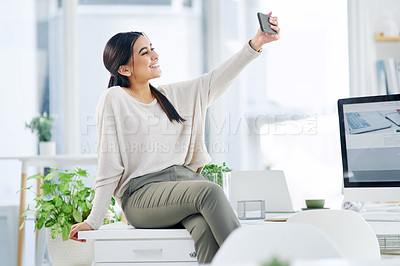 Buy stock photo Shot of a young businesswoman taking selfies in an office