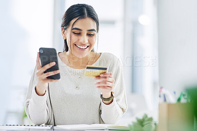 Buy stock photo Shot of a young businesswoman using a cellphone and credit card in an office