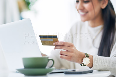 Buy stock photo Shot of a young businesswoman using a laptop and credit card in an office