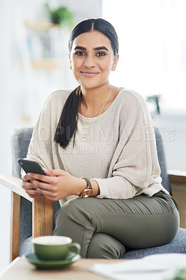 Buy stock photo Portrait of a young businesswoman using a cellphone in an office