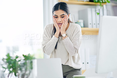 Buy stock photo Shot of a young businesswoman looking shocked while using a laptop in an office