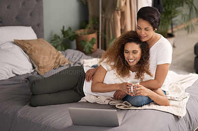 Buy stock photo Shot of a couple using a laptop while sitting on the bed at home