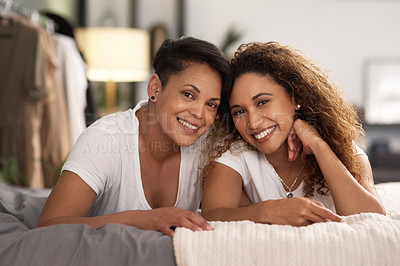 Buy stock photo Shot of a young lesbian couple relaxing in their bedroom at home