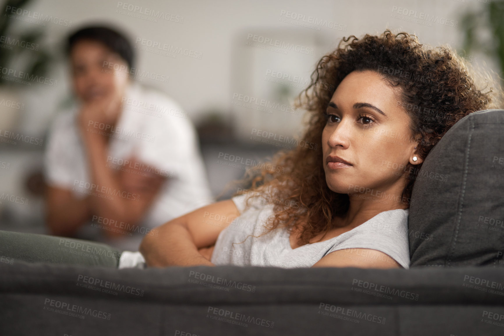 Buy stock photo Shot of a young woman ignoring her partner at home