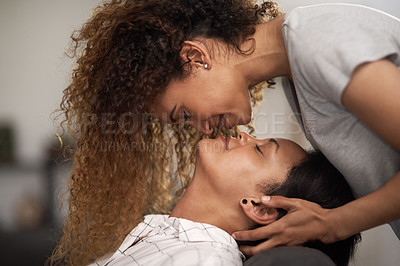 Buy stock photo Shot of an affectionate couple sharing a kiss at home