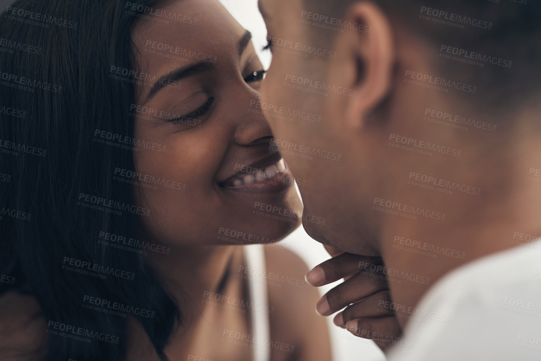 Buy stock photo Shot of a young couple sharing an intimate moment at home