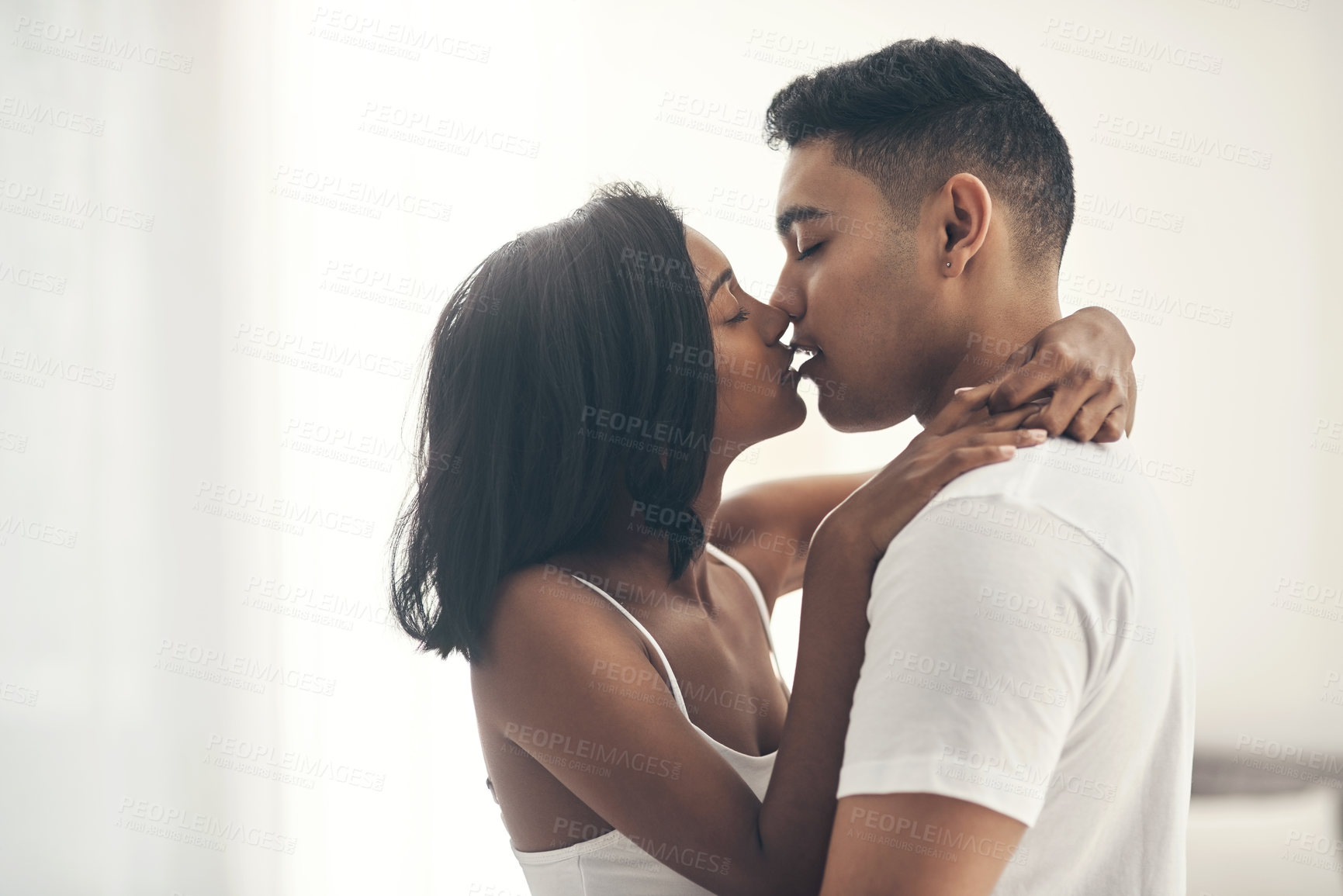 Buy stock photo Shot of a young couple sharing an intimate moment at home