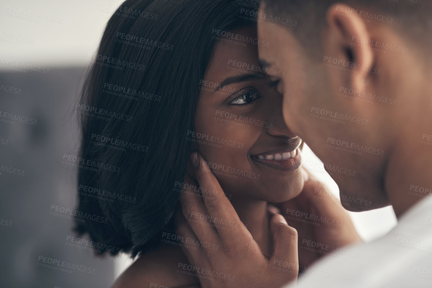 Buy stock photo Shot of a young couple sharing an intimate moment at home