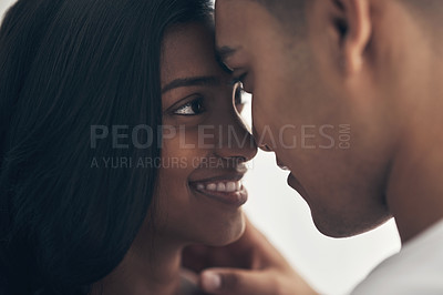 Buy stock photo Shot of a young couple sharing an intimate moment at home