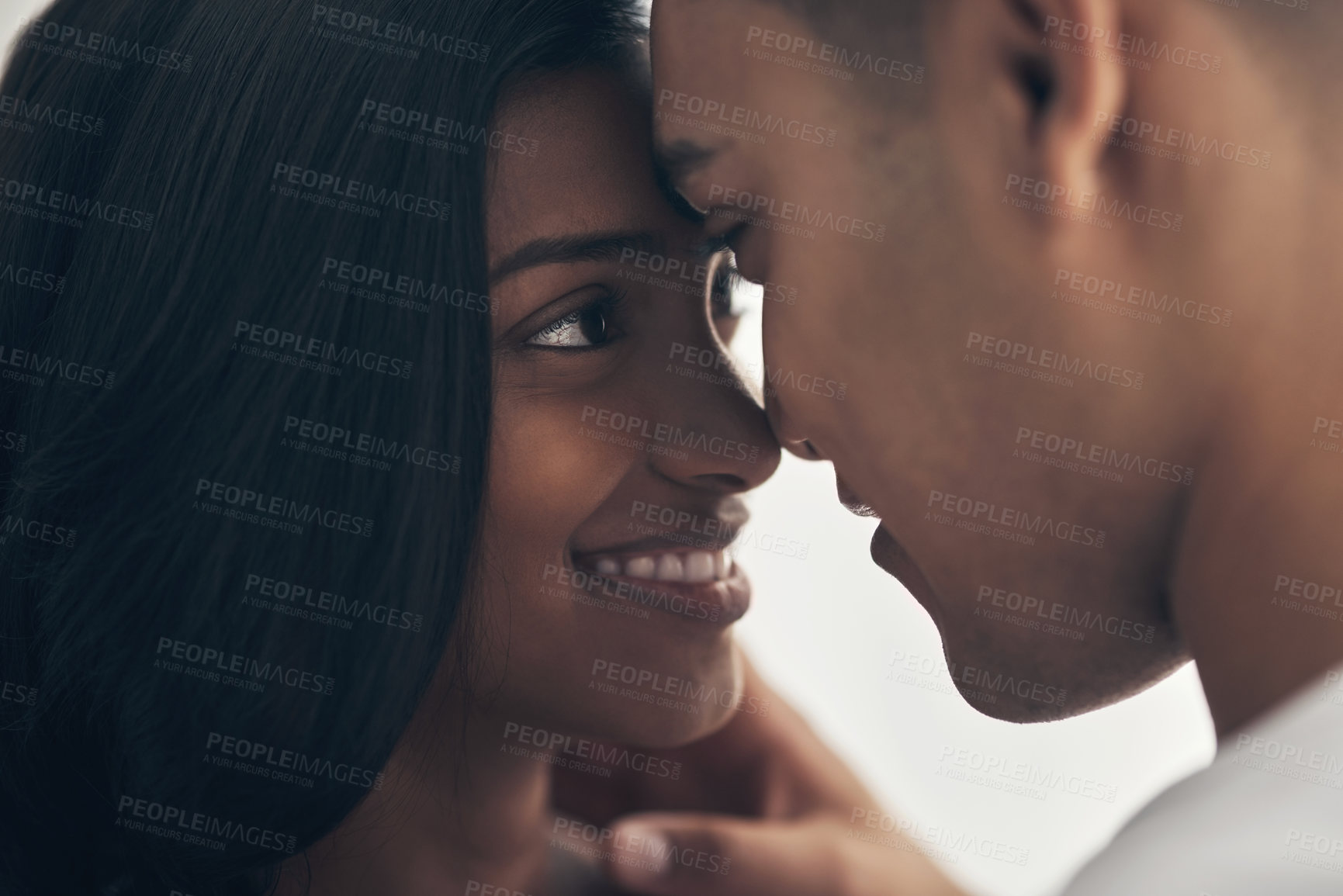 Buy stock photo Shot of a young couple sharing an intimate moment at home