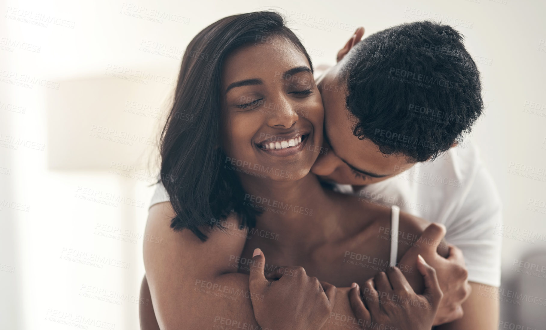 Buy stock photo Shot of a young couple sharing an intimate moment at home