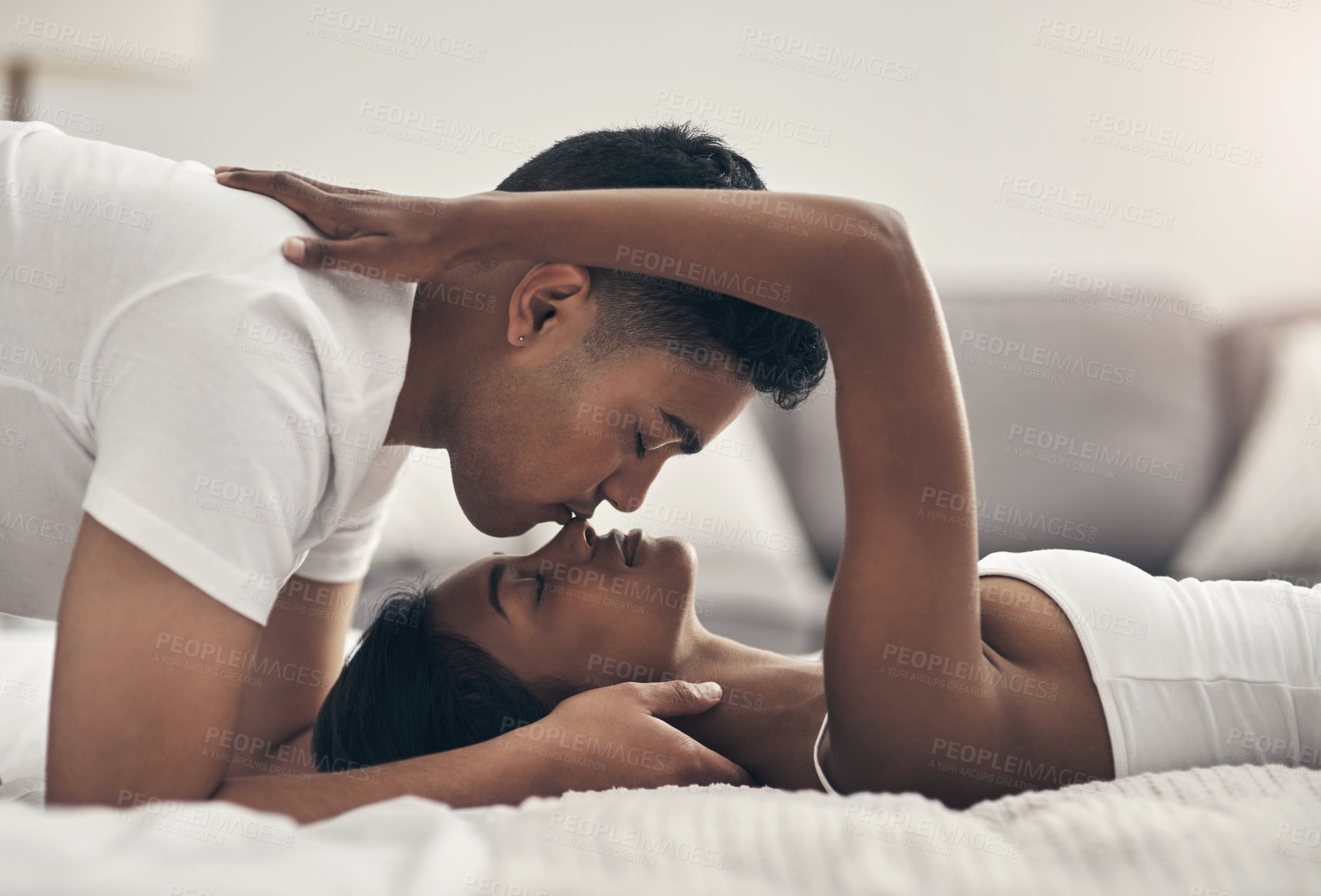 Buy stock photo Shot of a young couple sharing an intimate moment at home